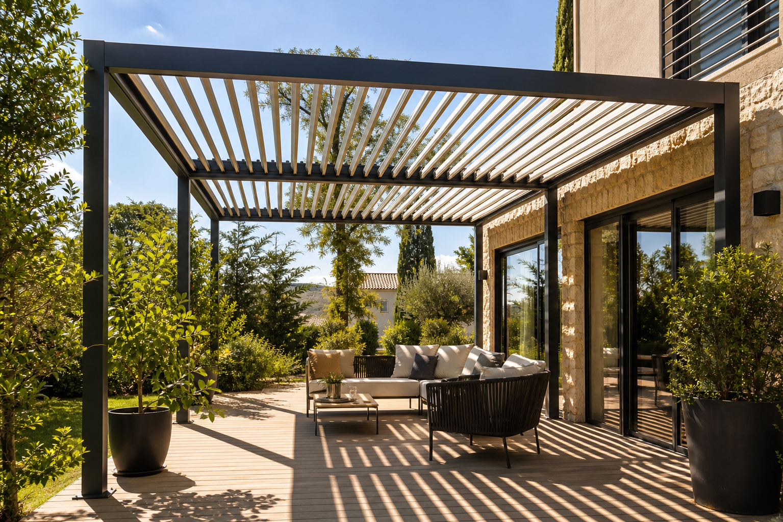 Pergola bioclimatique à lames orientables ouvertes au-dessus d'une terrasse ensoleillée avec mobilier de jardin